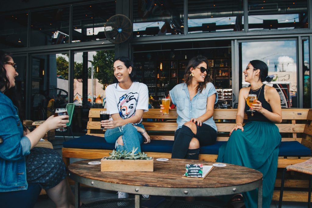 four women sitting in an outdoor patio