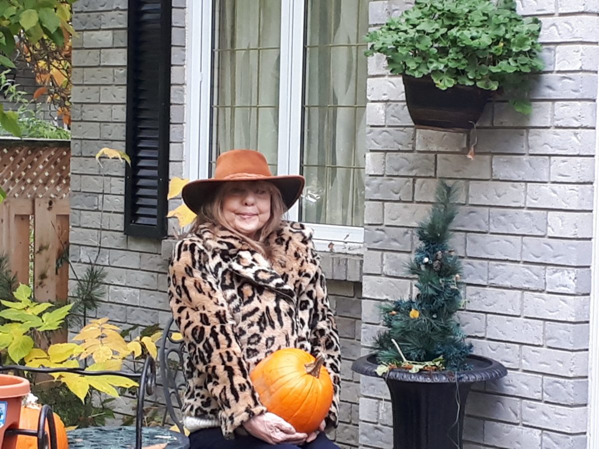 Dianna Graham holding a pumpkin outside her house