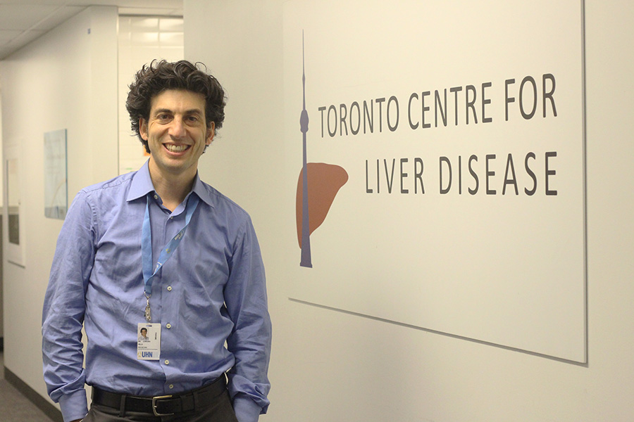 Dr. Jordan Feld, a liver specialist at UHN’s Toronto Centre for Liver Disease, standing in front of Toronto Centre for Liver Disease sign.
